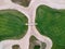 Aerial view of the green grass of the golf course. Bridge between hills