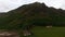 Aerial view of green hillside and rural area with old houses, environment