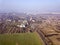 Aerial view of green and plowed fields and city suburbs on sunny dawn. Drone photography