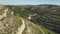 Aerial view of green rocky desert wild mountain area with winding road in Cyprus