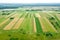 Aerial view of green rural landscape with patchwork of farmland under blue sky