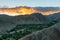 Aerial view of green valley in between high deserted mountains during sunset