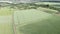 Aerial view on green wheat field in countryside. Field of wheat blowing in wind. Young and green spikelets. Barley crop in nature.