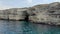 Aerial view of the grotto in a sheer cliff, Cape Tarkhankut, Black Sea, Crimean peninsula. Man in red swimming trunks