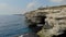 Aerial view of the grotto in sheer cliff, Cape Tarkhankut, Black Sea, Crimean peninsula. People look from above to the