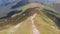 Aerial view Group of Travelers with Hiking Backpacks Climbs along Mountain Range