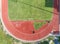 Aerial view on Half of soccer field, football field with Numbers on red running track.