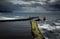 Aerial view of a harbor of a seaside town Whitby with a cloudy sky in the background, England