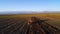 Aerial view of harvest fields with tractor. Farmer plowing stubble field