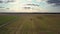 Aerial view harvester drives on endless green striped field