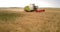 Aerial view harvester roll rotates cutting off wheat