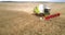 Aerial view harvesting tractor with red roll works in field