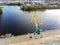 Aerial view of heavy crane loading bulk goods at Dnieper river cargo port terminal in Kiev at evening sunset time. Industrial