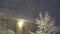 Aerial view of heavy snow storm fall on urban street, illuminated public lamp,