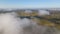 Aerial view from high altitude of landscape covered with puffy morning fog. Cold humid air condensing in rain clouds