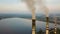 Aerial view of high chimney pipes with grey smoke from coal power plant. Production of electricity with fossil fuel.