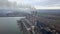 Aerial view of high chimney pipes with grey smoke from coal power plant. Production of electricity with fossil fuel.