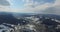 Aerial view. High over snowy rolling hills. Small town