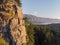 Aerial view of high stone rock, with green trees. Amazing landscape with highway, river cost and dense forest at the sunny weather