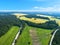 Aerial view of highway. Aerial view of a country road near the lake. Car passing by. Aerial road. Aerial view flying. Captured fro