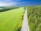 Aerial view of highway. Aerial view of a country road near the lake. Car passing by. Aerial road. Aerial view flying. Captured fro