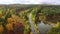 Aerial view of a highway in an autumnal forest from a drone