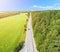 Aerial view of highway with car. Aerial view of a country road with moving car. Car passing by. Aerial road. Aerial view flying. C