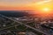 Aerial view at highway intersection or road junction with circle movement at sunset, cars and trucks traffic