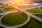 Aerial view at highway intersection or road junction with circle movement at sunset, cars and trucks traffic, drone shot