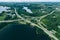 Aerial view of highway and overpass road with green woods and blue lakes in Finland
