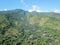 Aerial view of hills above Amed village in Bali. Hillsides densely covered with tropical vegetation and jungle. Houses of