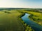 Aerial view from hot air balloon or aerostat or drone, summer landscape with forest, green meadows and river in countryside