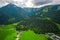 Aerial view of houses and buildings in lush green Tyrol, Austria between green mountains
