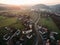 aerial view of houses church and green fields at foggy