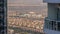 Aerial view of housing development promenade with JLT district skyscrapers and artificial lake with a park timelapse.