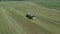 Aerial view how tractor making bales with with white film