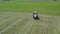 Aerial view how tractor making bales with with white film