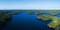 Aerial view of a huge lake surrounded by rural forest.