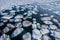 an aerial view of ice floes floating in the water near the shore of a frozen lake in the snow covered landscape of the arctic