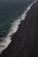 Aerial view of Iceland ocean wave cresting on black sand beach
