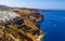 Aerial view of idyllic Fira town with white buildings on high coast, Santorini island in Greece