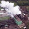 Aerial view. Industry, industry and ecology problem. White smoke of the peat plant polluties the environment