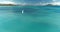 Aerial view of kite surfer, slow motion, white kite and hydrofoil, color graded