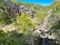 Aerial view lacy appearance of travertine cliffs with Arbuckle Mountain at Bridal Veil Falls, where Honey Creek feeds scenic