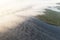 Aerial view lake with fog above water surface and sunrise over forest. Top view amazing seashore with fog over the water and green