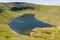 Aerial view of a lake formed at the base of green mountains Llyn y Fan Fach, Brecon Beacons, Wales