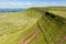 Aerial view of a lake formed at the base of green mountains Llyn y Fan Fach, Brecon Beacons, Wales