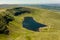 Aerial view of a lake formed at the base of green mountains Llyn y Fan Fach, Brecon Beacons, Wales