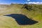 Aerial view of a lake formed at the base of green mountains Llyn y Fan Fach, Brecon Beacons, Wales