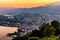 Aerial view of the lake Lugano surrounded by mountains and evening city Lugano on during dramatic sunset, Switzerland, Alps.